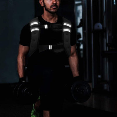 homme gymnase sombre gilet lesté bande lumineuse poids en mains