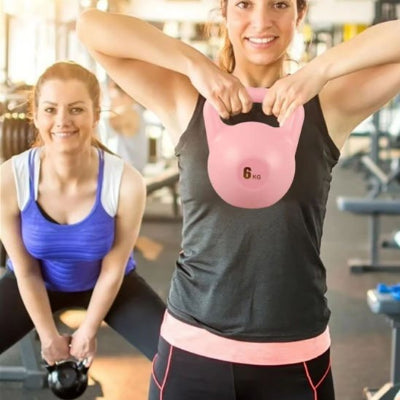 Une fille squatte l'autre soulève sa kettlebell à deux mains