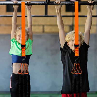 Deux enfants suspendus horizontalement a une sangle musculation orange