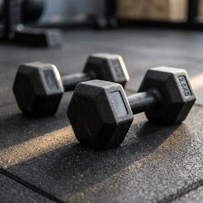 Deux haltères hexagonaux noirs sur le sol de 2,5 kg chacun