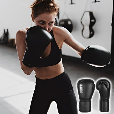 Femme avec gant boxe noir déterminé prête au combat
