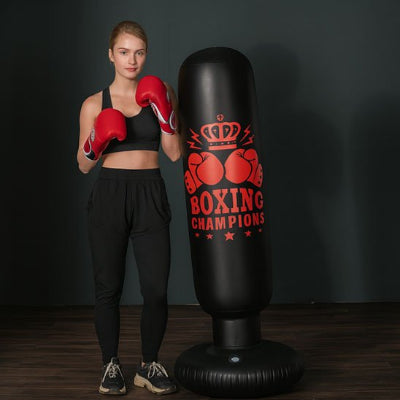 femme avec gants de boxe couronne sur sac de frappe