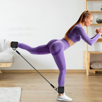 femme dans le salon etirement de jambe avec Elastique musculation