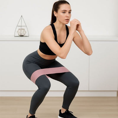 Femme effectuant des squats avec une bande Elastique musculation​ 
