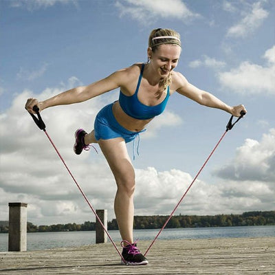 Femme en appui sur une jambe bras écartés élastiques musculation​ 