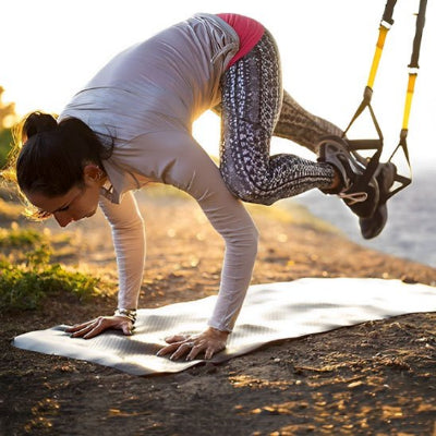 Femme en suspension extérieur pied retenus par musculation sangle 