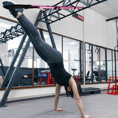 Femme exercice salle de sport position planche avec musculation sangle