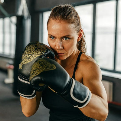 Femme gant de boxe noir orné de motifs dorés tigre