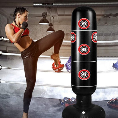 femme tenue sport s'entraine sur sac de frappe gonflable noir