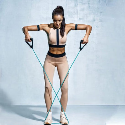 Femme tenue sport utilisant élastiques musculation​ croisée maintenue au sol