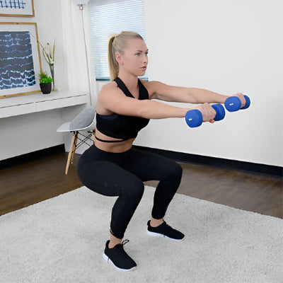 fille blonde sur un tapis position sguat avec haltere