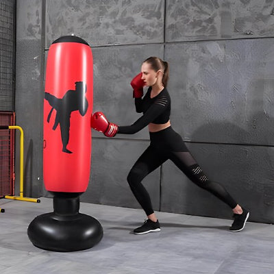 Fille pratique coup de poing sur sac de frappe gonflable