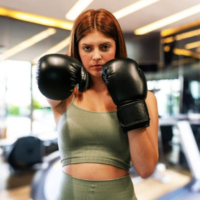 Fille rousse un coude plié bras tendu gants de boxe
