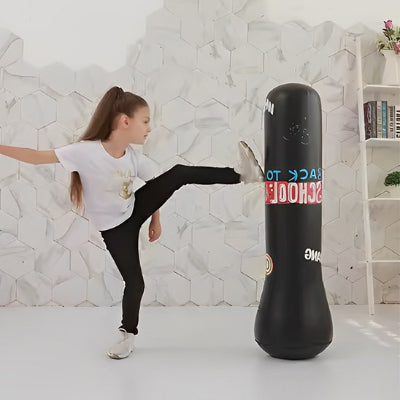 Fillette frappe avec son pied sur sac de frappe enfant