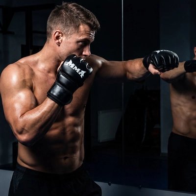Gant de boxe MMA noir porte pendant un entrainement de frappe