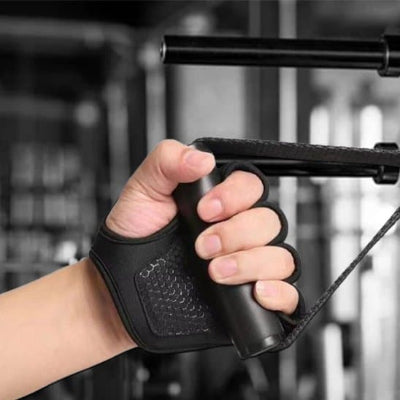Gant musculation noir tenant la poignee d une machine de sport