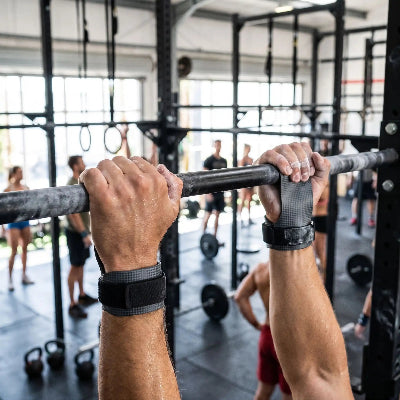 Gant pour musculation gris mains entourant la barre pour maximiser la force