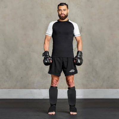 gants de boxe noirs il porte protege tibia boxe noir