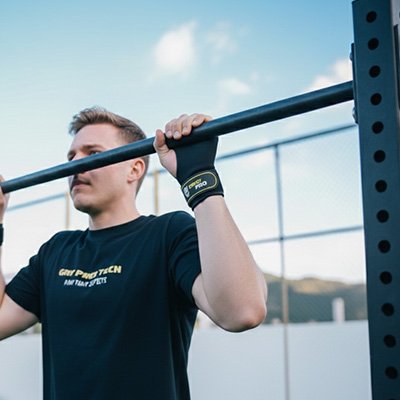 Homme à la barre se soulève avec sangle de tirage 