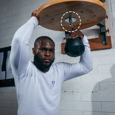 homme avec une main stabilise le support sac de frappe