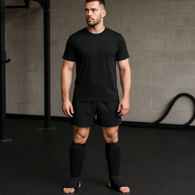 homme debout regarde de cote avec protege tibia boxe