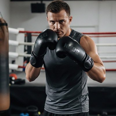 Homme en position de combat avec  gant de boxe noir