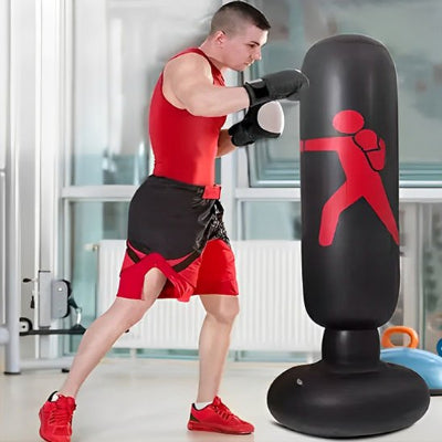 Homme entrain de frapper un sac de frappe gonflable autoportant