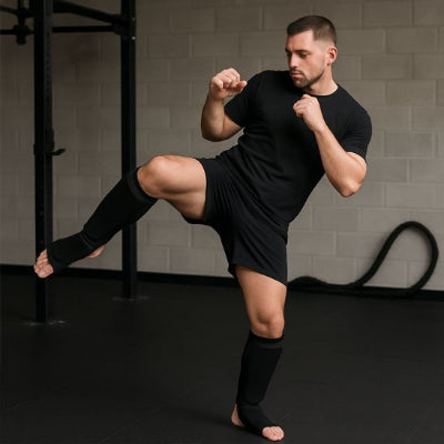 homme execute un coup de pied circulaire avec protege tibia boxe