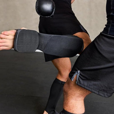 homme fait de entrainement de boxe avec protege tibia boxe
