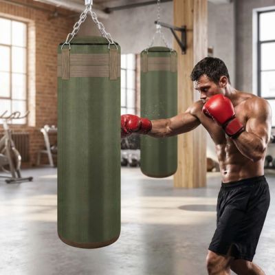 homme frappant sur un sac de boxe vert gants rouges