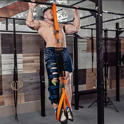 Homme suspendu horizontalement en salle avec une sangle musculation