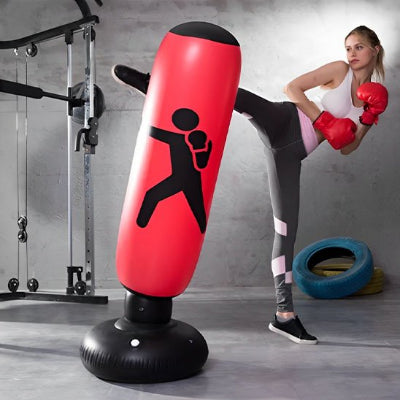 Jeune femme fait exercice utilisant un sac de frappe gonflable