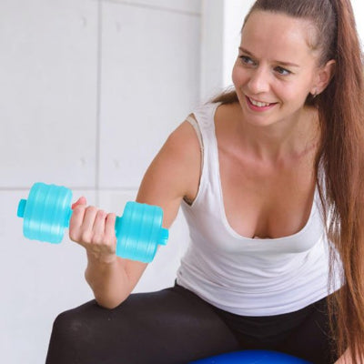Jeune femme souriante fait de l exercice avec haltères bleus