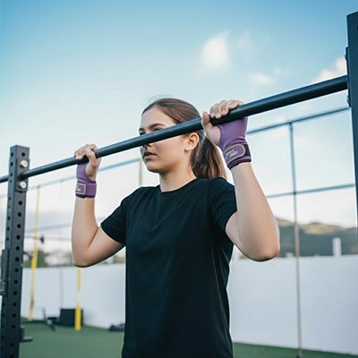 Jeune fille chandail noir tient barre avec sangle de tirage 