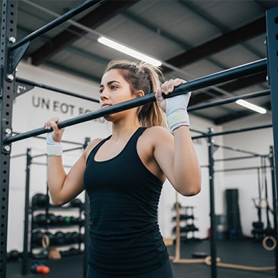 Jeune fille cheveux attachés, levée olympique avec sangle de tirage 