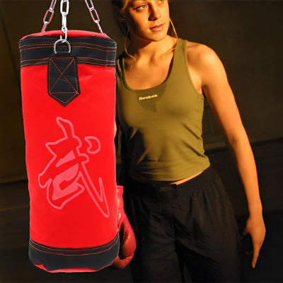 La fille a fini de frappé sur son sac de frappe 