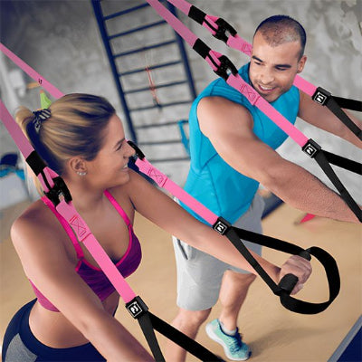 Mari et femme se regardent en faisant exercice musculation sangle