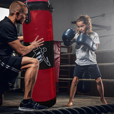 pere et fils pratiquant sur leur sac de frappe