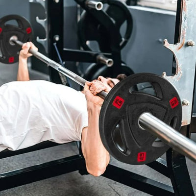 Personne étendue sur banc avec une barre et disque musculation 