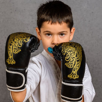  Petit garçon avec protège-dents bleu et gant de boxe 